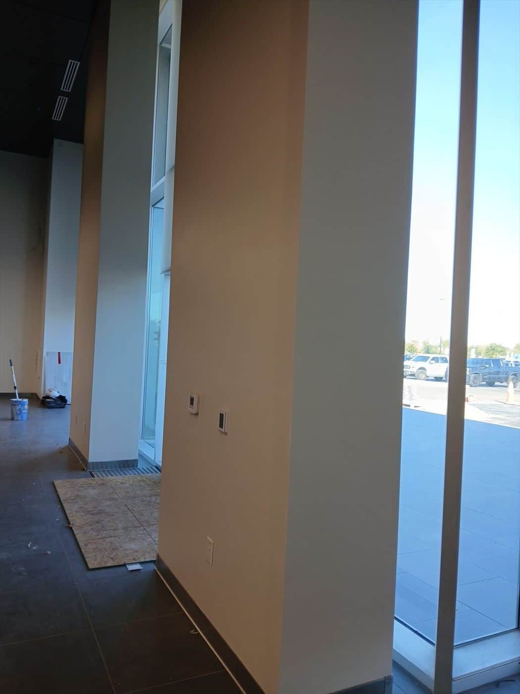 Tan-painted entry columns and glass storefront overlooking the parking lot.