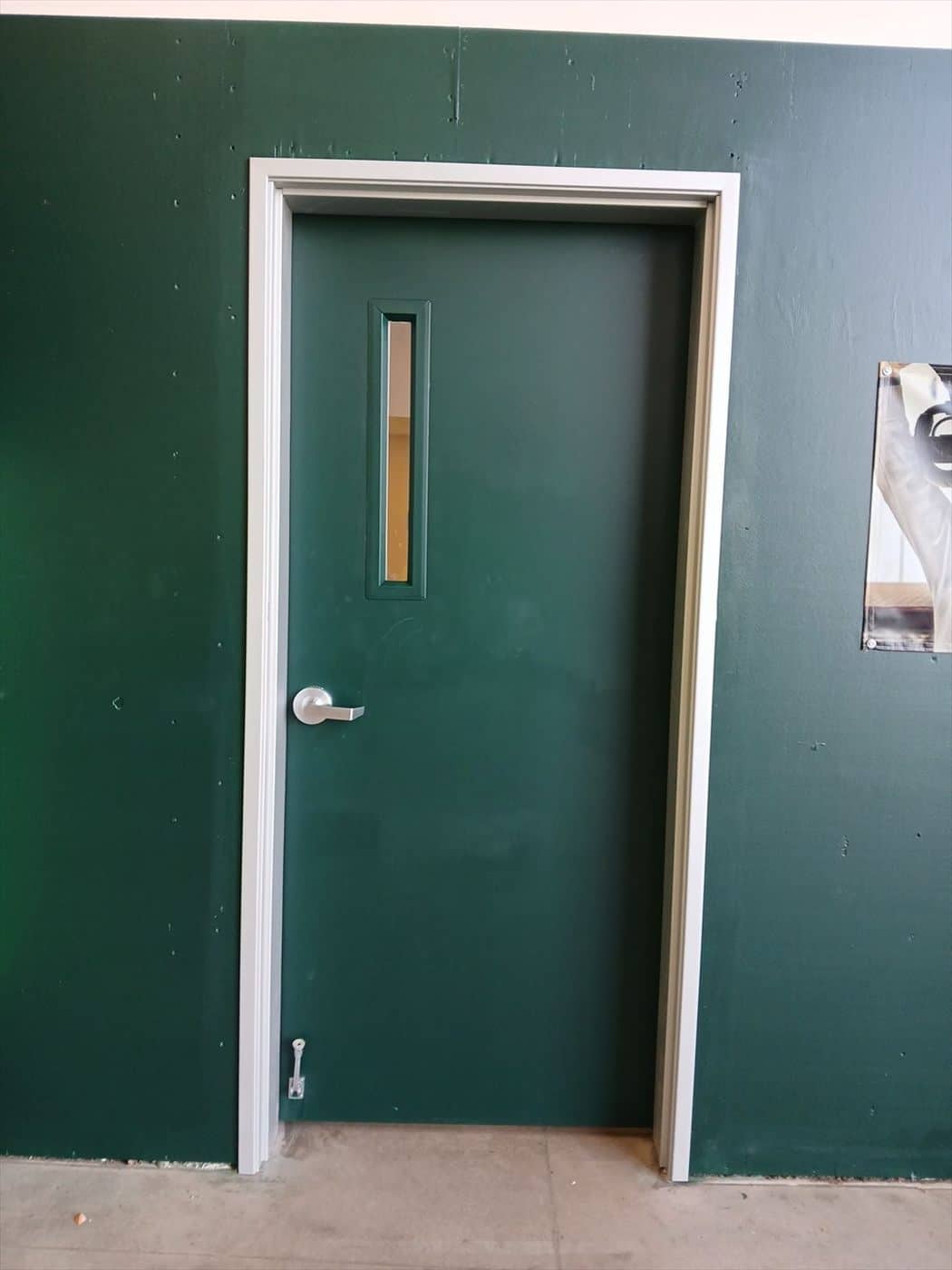 Dark green painted wall around a white-framed interior door.