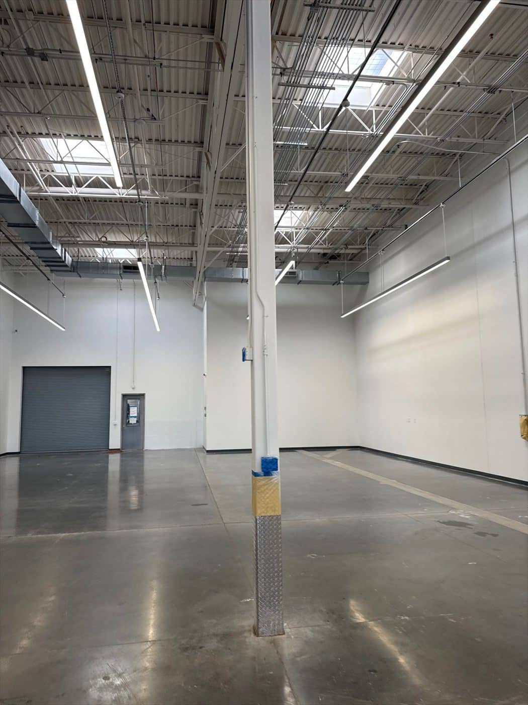 Finished service-bay interior with polished concrete floor and painted structural column.