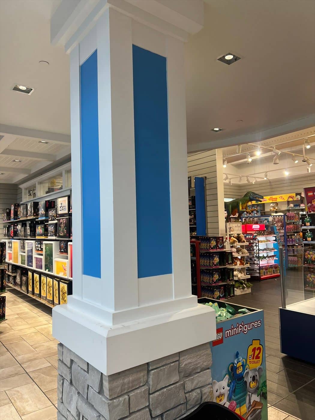 Freshly painted retail column with blue and white two-tone finish on a stone base in the store.