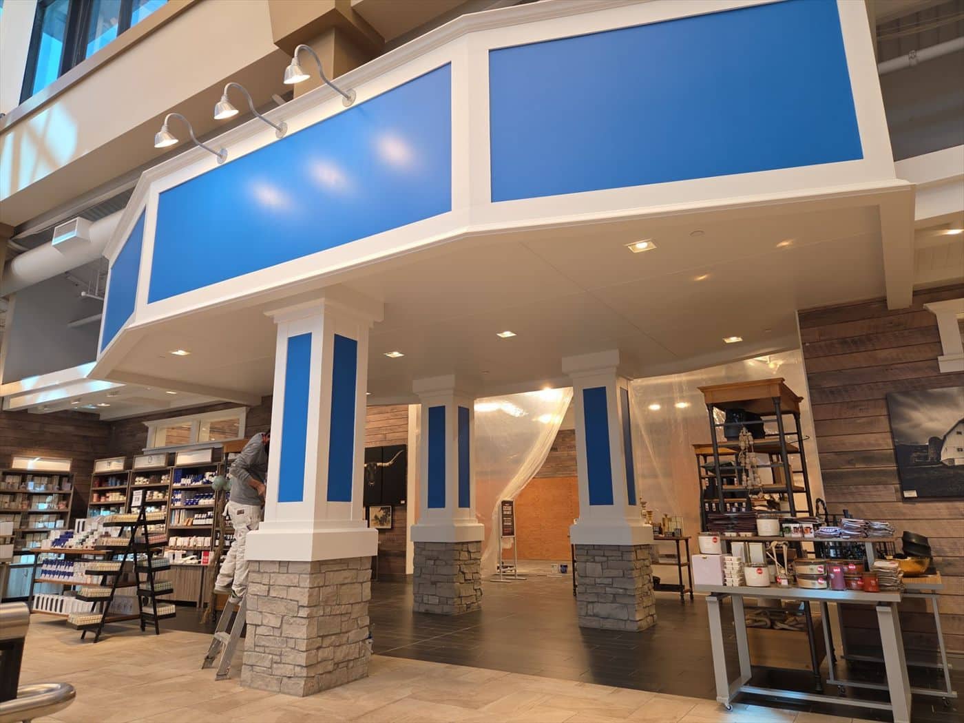 Completed blue-and-white painted entrance columns and soffit framing a store department.