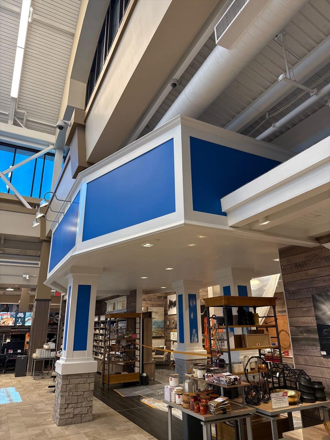 Completed white entry soffit with blue accent panels and columns over the retail sales floor.