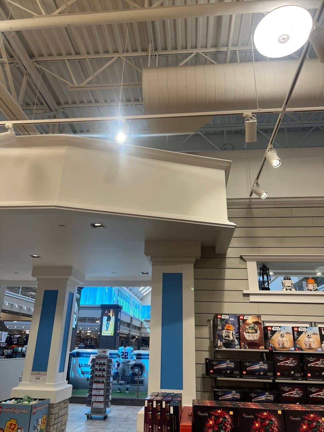 Painted white soffit fascia and blue accent columns near the exposed ceiling of the retail store.