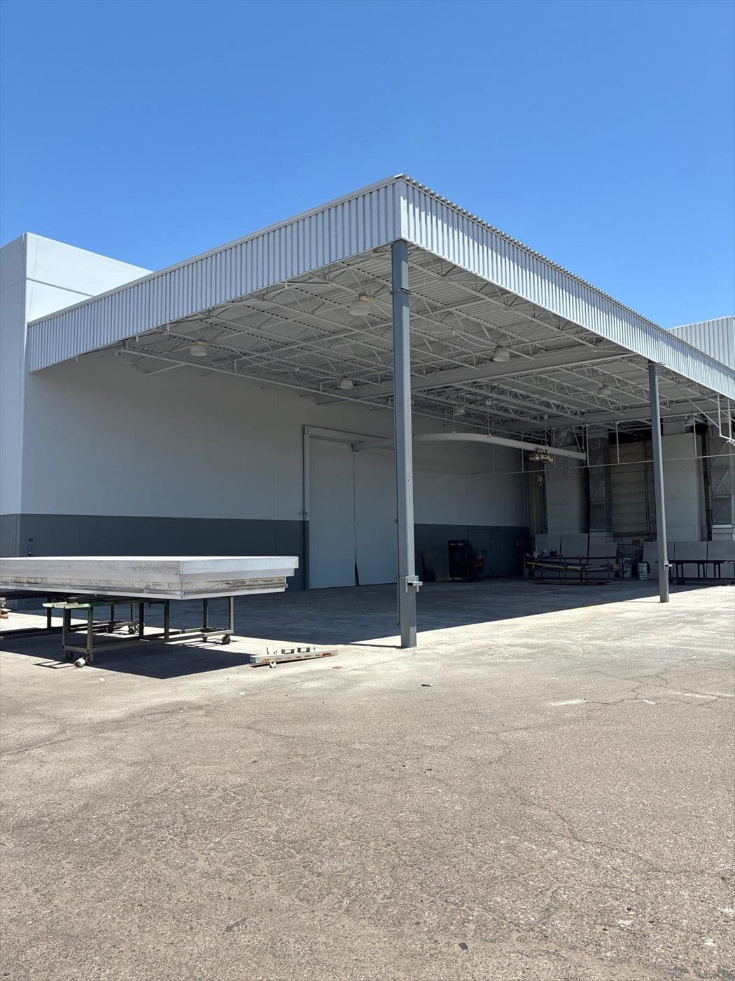 Exterior covered canopy area attached to the warehouse with completed two-tone wall paint.