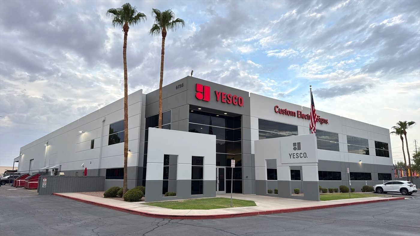 Corner view of the finished YESCO office building with palm trees and repainted facade.