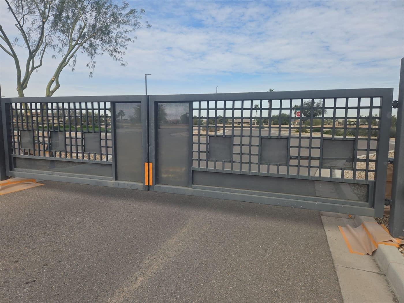 Large gray sliding entry gate at a community access point.