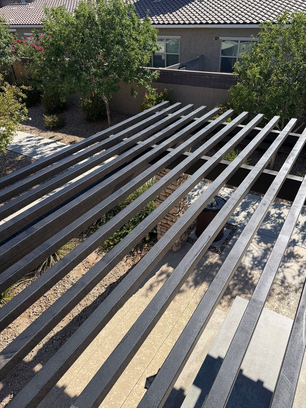 Overhead view of a metal slat pergola between community homes.