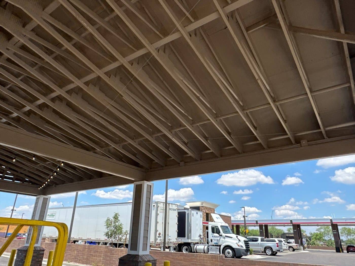 The painted underside of the drive-thru canopy with a semi-truck and lot visible beyond.