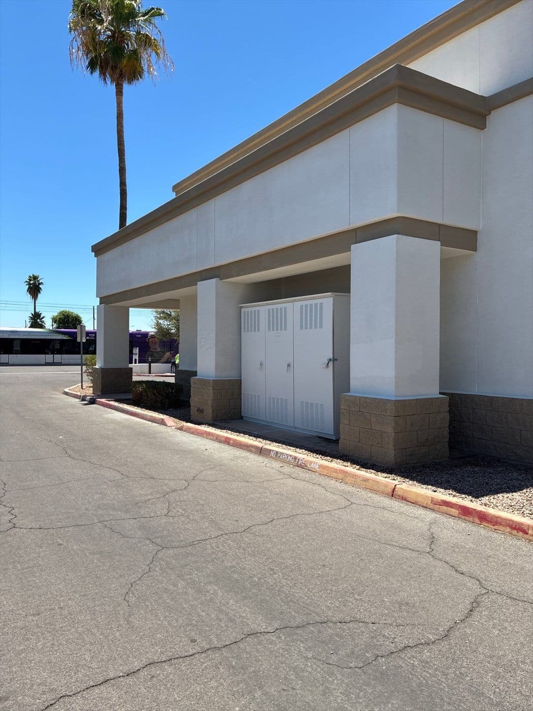 Completed covered entry drive with repainted columns and utility doors.