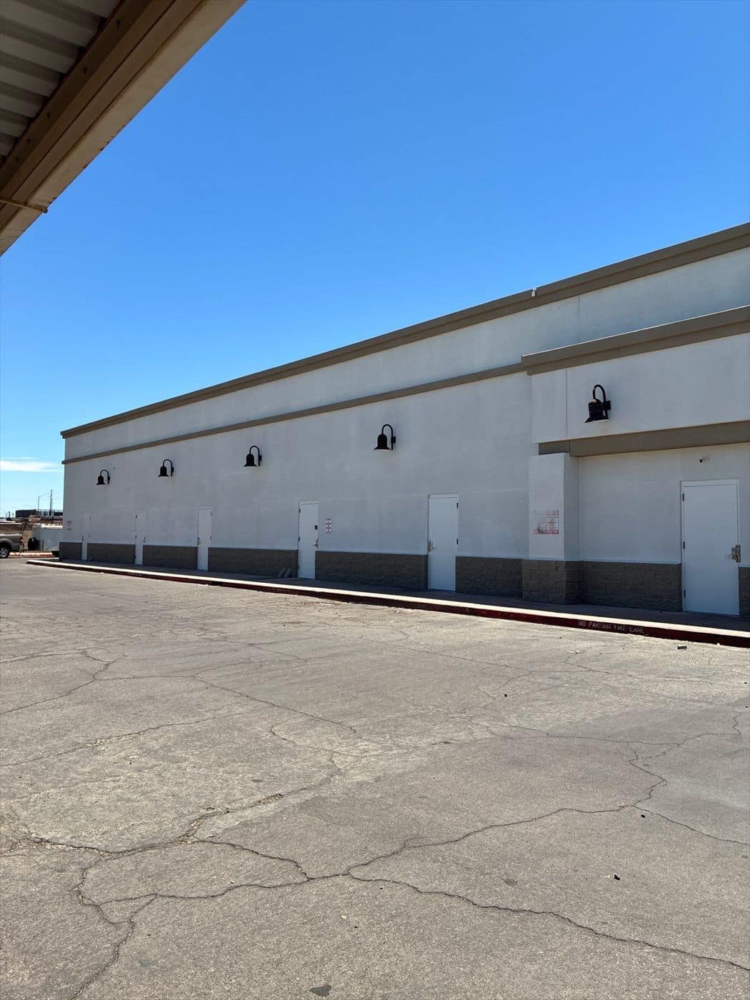 Finished side elevation of the building with repainted doors and light fixtures.