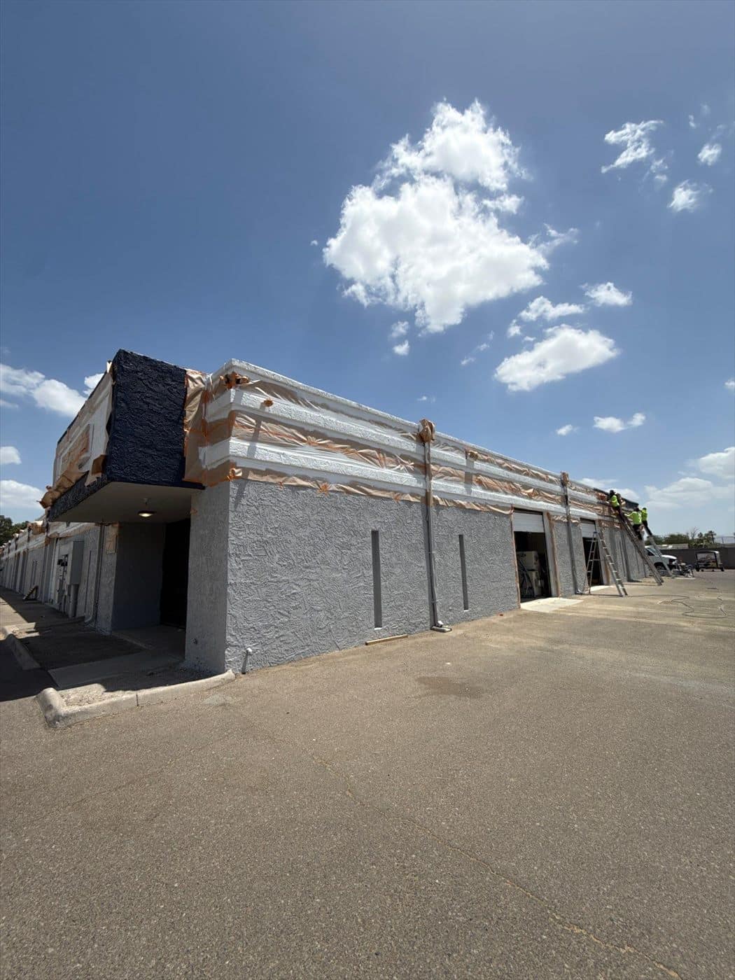 Completed gray-and-navy side wall with a roof access ladder and utility penetrations.