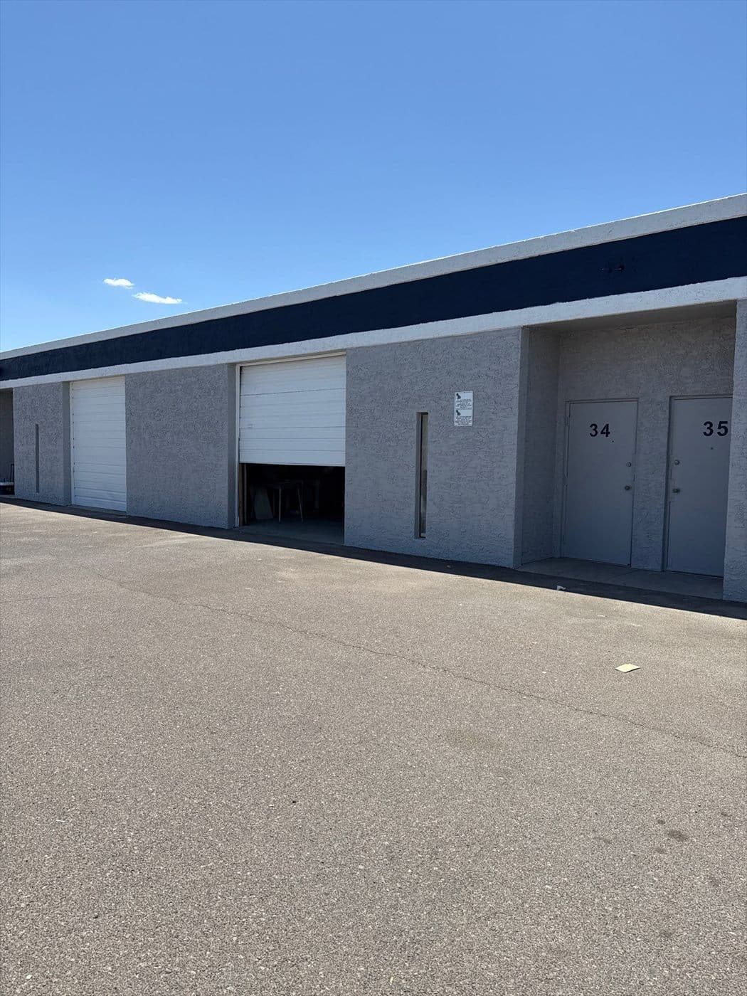 Completed warehouse elevation with a white roll-up door and tenant unit numbers 34 and 35.