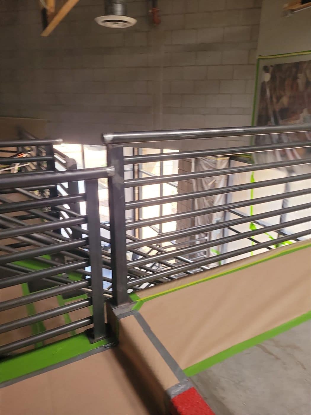 Close-up of a masked gray-painted metal railing corner joint.
