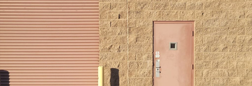 Rolling steel door and personnel door repainted by ACP Commercial Painting Company in Tempe, AZ