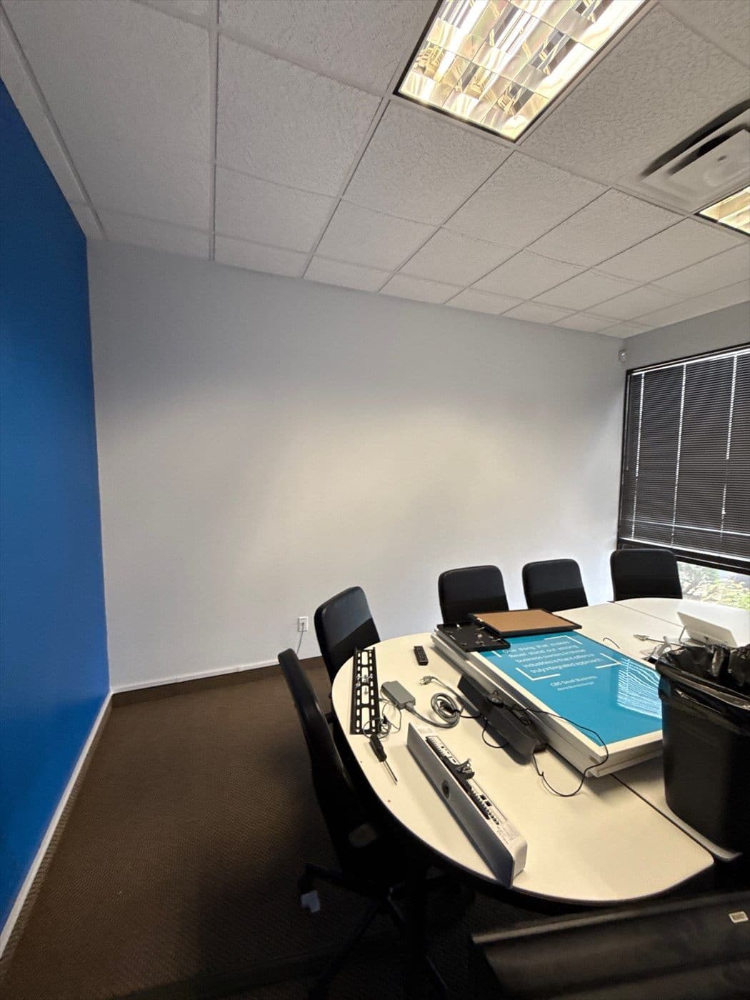 Conference room with oval table and a blue accent wall painted.