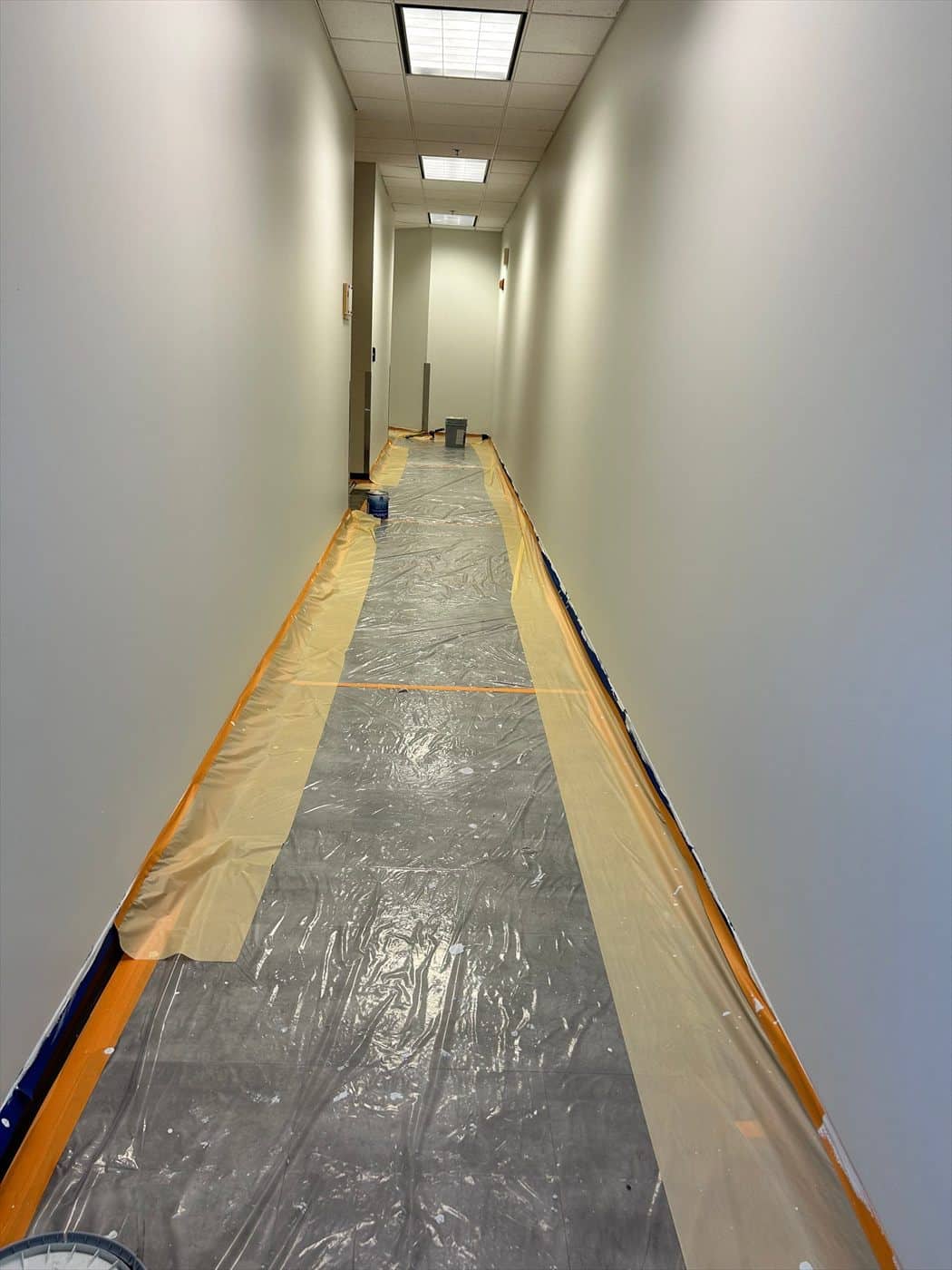 Completed hallway with clean painted walls and masked flooring throughout.