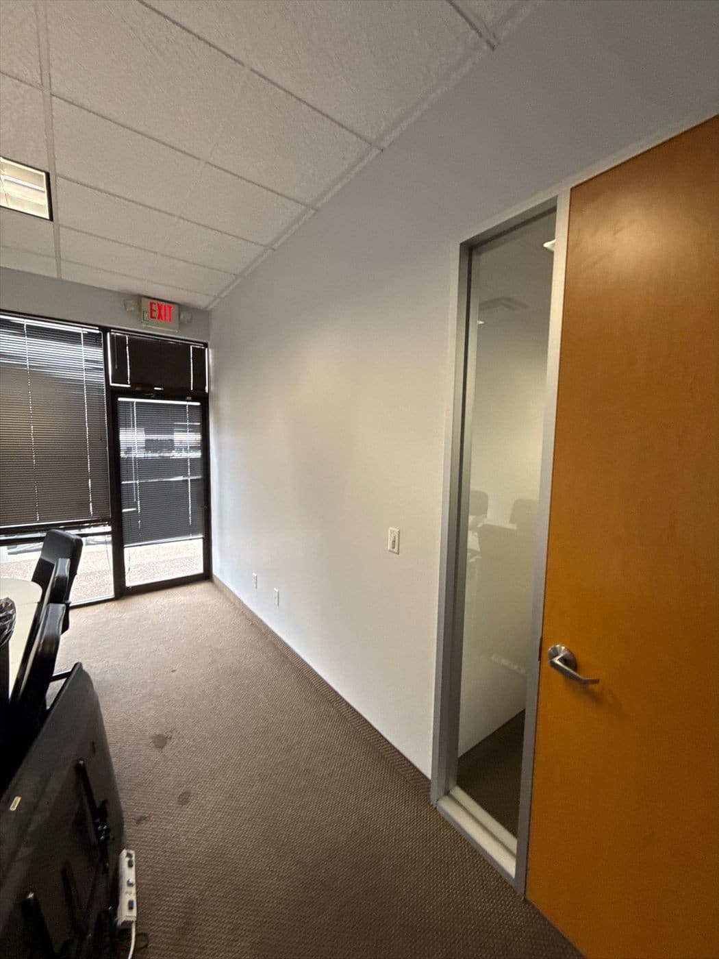 Painted office corridor with a glass-panel door and wood entry door.