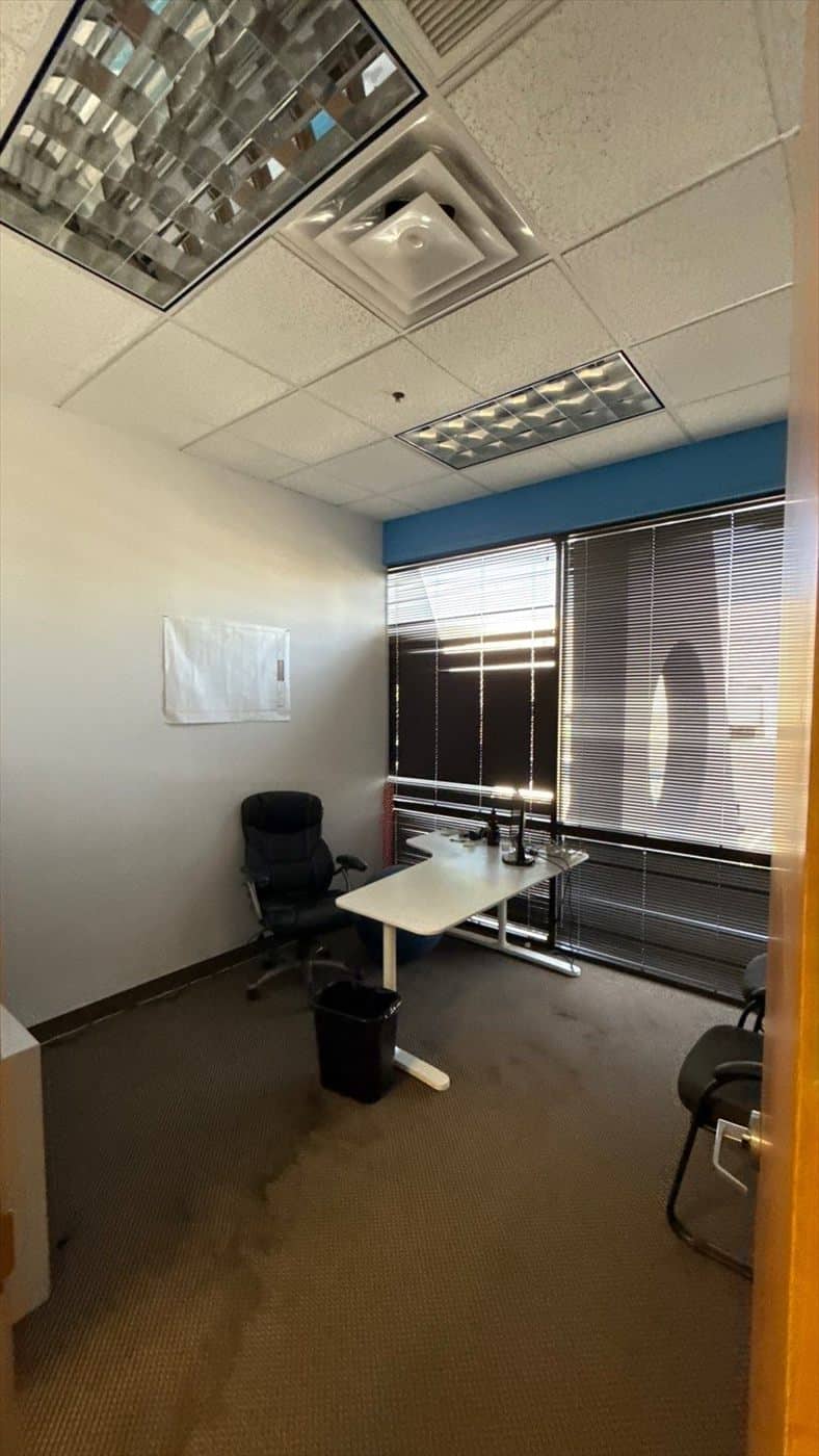 Small office with desk, chair, and blinds before painting begins.