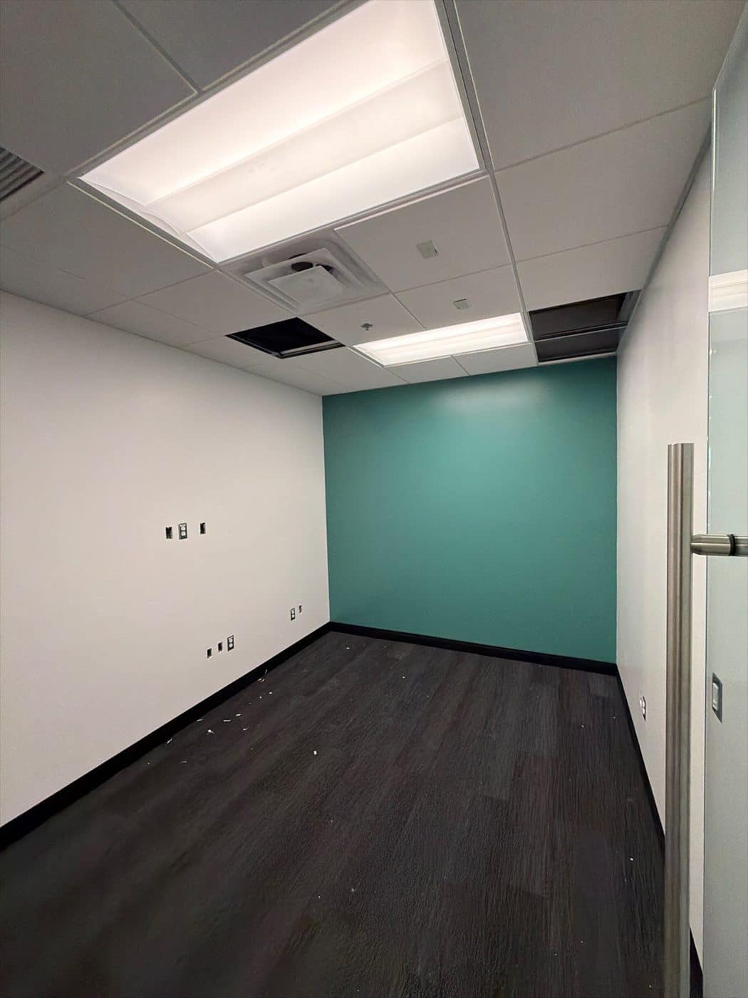 Finished office with white walls, teal accent wall, and completed drop ceiling.