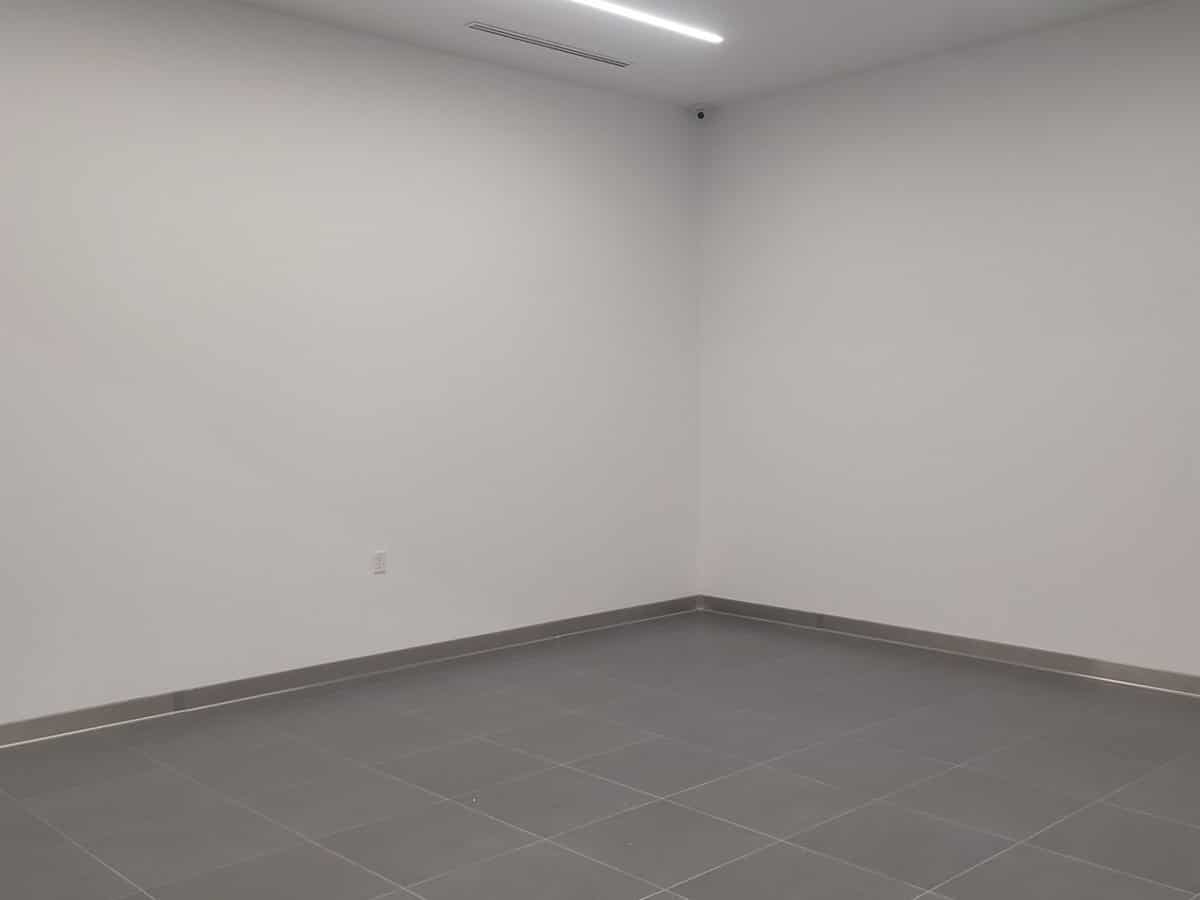 Freshly repainted white office room with gray tile floor and linear lighting in a Casa Grande commercial building, painted by ACP Commercial Painting Company