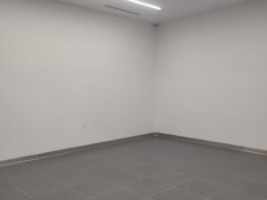 Freshly repainted white office room with gray tile floor and linear lighting in a Casa Grande commercial building